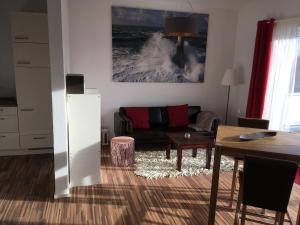 a living room with a couch and a table at Seeterrasse in Allensbach
