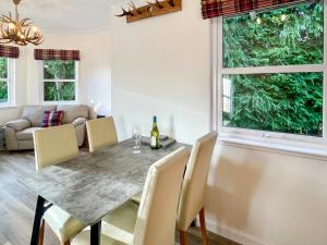 a dining room with a table and chairs and a window at Dee View Apartment in Banchory