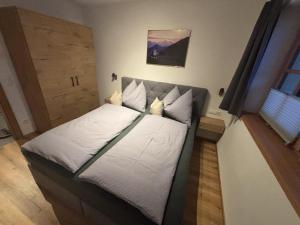a small bedroom with a bed with white sheets at Apartment Bichlhof in Brixen im Thale +11 photos
