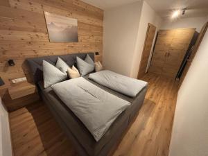 a couch in a room with a wooden wall at Apartment Bichlhof in Brixen im Thale