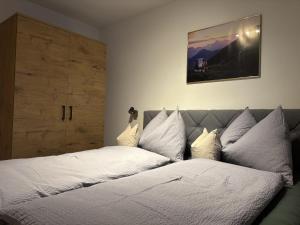a bedroom with a bed with white sheets and pillows at Apartment Bichlhof in Brixen im Thale