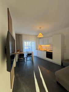 a kitchen and living room with a table and chairs at Schönes Apartment für 5 Personen nahe Zentrum & Borussia Park MG77 in Mönchengladbach +3 photos