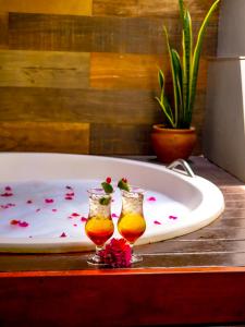 Dos vasos en una mesa junto a una bañera. en Canoé Brasil, en Praia de Moitas