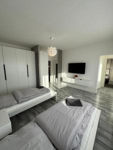 a bedroom with two beds and a flat screen tv at Schönes Apartment für 5 Personen nahe Zentrum & Borussia Park MG77 in Mönchengladbach
