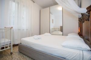 a bedroom with a large white bed with a mirror at Apartment with Free Parking Easy Access to Venice in Mestre