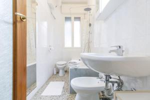 a white bathroom with a sink and a toilet at Apartment with Free Parking Easy Access to Venice in Mestre +22 photos