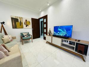 ein Wohnzimmer mit einem Flachbildfernseher auf einem Entertainment-Center in der Unterkunft Casa c/ Suíte, Ar Cond, Área Gourmet, Bairro Nobre in Ourinhos