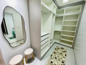 ein Ankleidezimmer mit einem Spiegel und einem Stuhl in der Unterkunft Casa c/ Suíte, Ar Cond, Área Gourmet, Bairro Nobre in Ourinhos + 33 Fotos