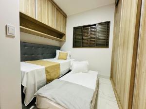 ein Zimmer mit zwei Betten und einem Fenster in der Unterkunft Casa c/ Suíte, Ar Cond, Área Gourmet, Bairro Nobre in Ourinhos