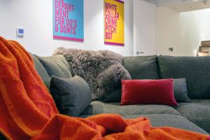 a gray couch with red pillows in a living room at St James Central Splendor in Bath