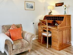 een kamer met een bureau en een stoel naast een bureau bij Swaleside Cottage in Topcliffe