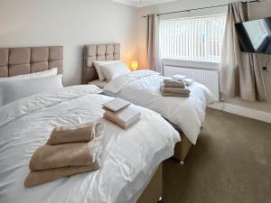 een slaapkamer met twee bedden met handdoeken erop bij Swaleside Cottage in Topcliffe +5 foto's