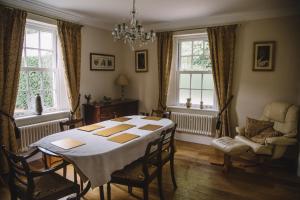 a dining room with a table and chairs and windows at Wayside , 3 bed , 2 bath charming house close to Lincoln in Lincoln