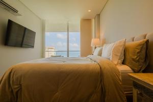 a bedroom with a bed and a couch and a television at Modern apt with 2 BR BBQ and views in Pendales +42 photos