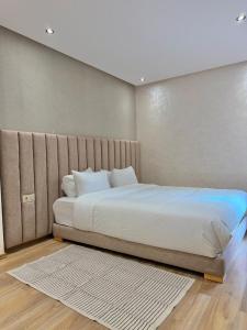 a bedroom with a large bed with white sheets at Villa 2 Évasion Urbaine, 3 Chambres, à 20 min de Rabat in Sidi Yahia az Zaʼer