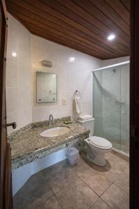 a bathroom with a sink and a toilet at Pousada Nusa Dua Maresias in Maresias +55 photos