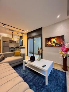 a living room with a couch and a fireplace at Villa 2 Évasion Urbaine, 3 Chambres, à 20 min de Rabat in Sidi Yahia az Zaʼer