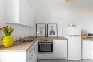 eine Küche mit weißen Geräten und einer gelben Vase mit Blumen in der Unterkunft ANTA Salt Mine City in Wieliczka