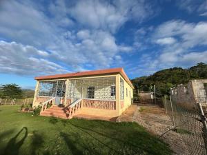 une petite maison avec une terrasse dans une cour dans l'établissement Apartamentos-Oliver, à Las Galeras