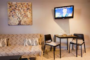 a living room with a couch and a table and a tv at Nero Apartment in Agrinion