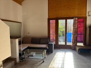 a living room with a couch and a window at Gemütliche Gartenwohnung im Tessin, 70 qm in Biasca