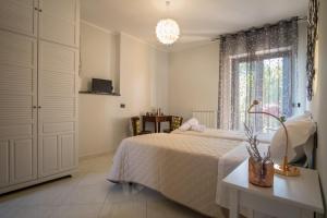 een witte slaapkamer met een bed en een raam bij Geo House in Termoli