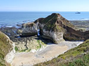 a large rock formation on a beach near the ocean at Robin in Flamborough