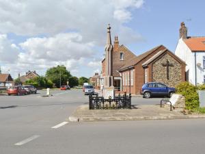 a church with a cross on the side of a street at Robin in Flamborough