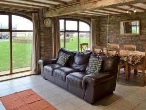 a leather couch in a living room with a table at Robin in Flamborough