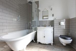 a bathroom with a tub and a toilet and a sink at The Plough Inn in Dorking
