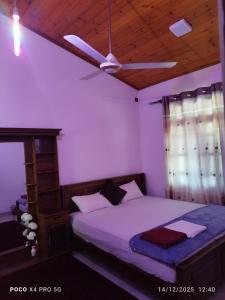 Un dormitorio con una cama y un ventilador de techo. en Edmon Beach Villa, en Dodanduwa