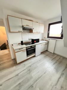 una cucina con mobili bianchi, un lavandino e una finestra di Gröpelinger Guesthouse a Brema