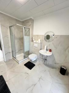 un bagno con doccia, WC e lavandino di Gröpelinger Guesthouse a Brema