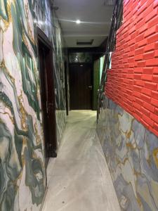ein Flur mit einer roten Backsteinwand neben einer Tür in der Unterkunft Hotel Zirakpur ZKR in Zirakpur