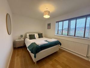 een slaapkamer met een bed en een groot raam bij Spacious 4-Bed Home in Ascot in Ascot