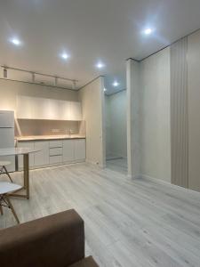 een lege kamer met een keuken en een tafel bij Кокшебель Жк in Astana