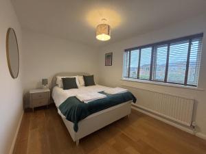 a bedroom with a bed and a large window at Spacious 4-Bed Home in Ascot in Ascot