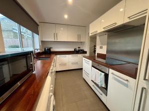 een keuken met witte kasten en houten vloeren bij Spacious 4-Bed Home in Ascot in Ascot