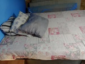 una cama con dos almohadas encima en Hostel & Cia Itanhaém, en Itanhaém