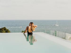 a woman sitting in the water in a swimming pool at Aguas de Ibiza Grand Luxe Hotel - Small Luxury Hotel of the World in Santa Eularia des Riu