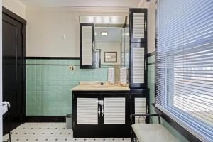 ein Badezimmer mit Waschbecken und Spiegel in der Unterkunft Suites On Chocolate - The Hershey House in Hershey