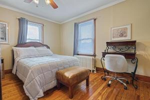 ein Schlafzimmer mit Bett, Stuhl und Schreibtisch in der Unterkunft Suites On Chocolate - The Hershey House in Hershey