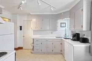 eine Küche mit weißen Schränken und einem weißen Kühlschrank in der Unterkunft Suites On Chocolate - The Hershey House in Hershey + 13 Fotos