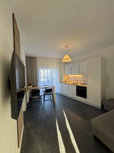 a kitchen and living room with a table and chairs at Schönes Apartment für 5 Personen nahe Zentrum & Borussia Park MG77 in Mönchengladbach