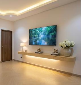 Una sala de estar con un televisor en la pared. en The Escape Kamala, en Kamala Beach