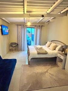 a bedroom with a bed in a room with a window at Enez Place in Gqeberha +15 photos