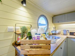 een keuken met een spoelbak en een welkomstbord op het aanrecht bij Heather - Uk34841 in Straiton