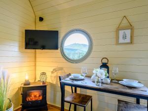 een kamer met een tafel met een open haard en een raam bij Heather - Uk34841 in Straiton