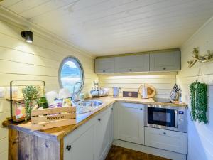 een keuken met witte kasten en een raam bij Heather - Uk34841 in Straiton