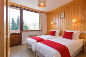 duas camas em um quarto de hotel com janela em Résidence & Spa La Grande Cordée - Combloux em Combloux